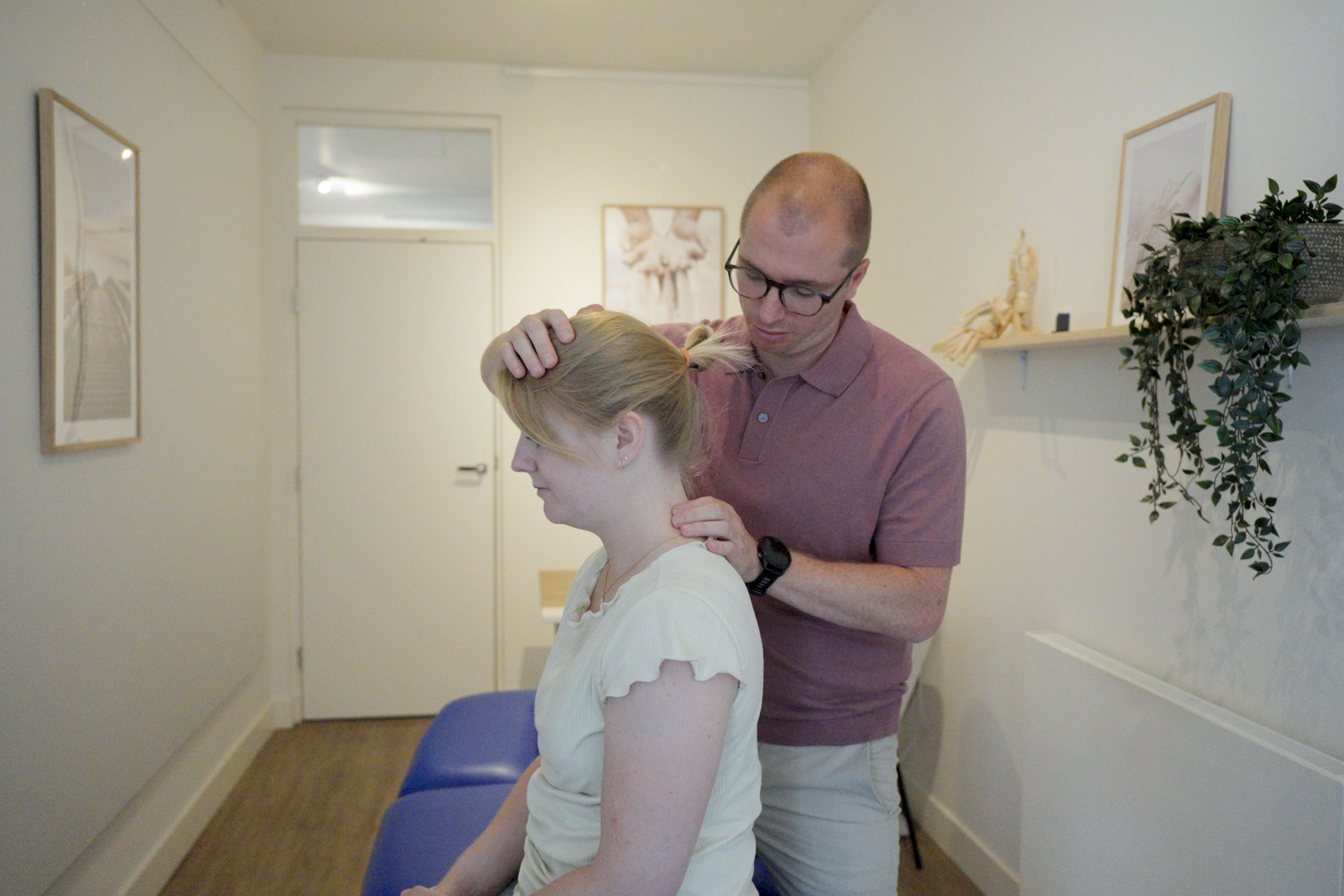 Maurice onderzoekt de nek en schouder van een patiënt bij Grip Healthcare